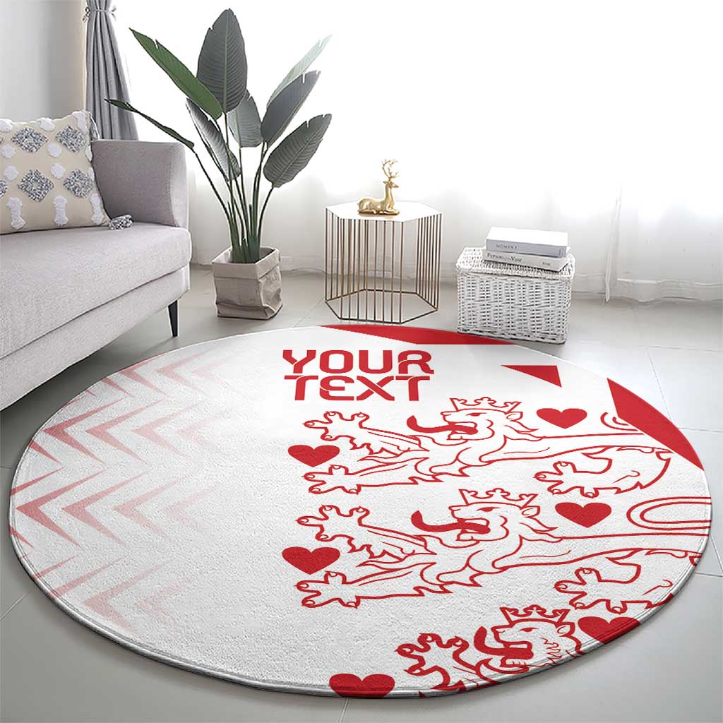 Round carpet in living room, light gray with red 'YOUR TEXT' and lions hearts motif