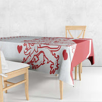 Red and white patterned tablecloth on a small table with chair bench