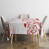 Red and white patterned tablecloth covering a dining table with chair sides