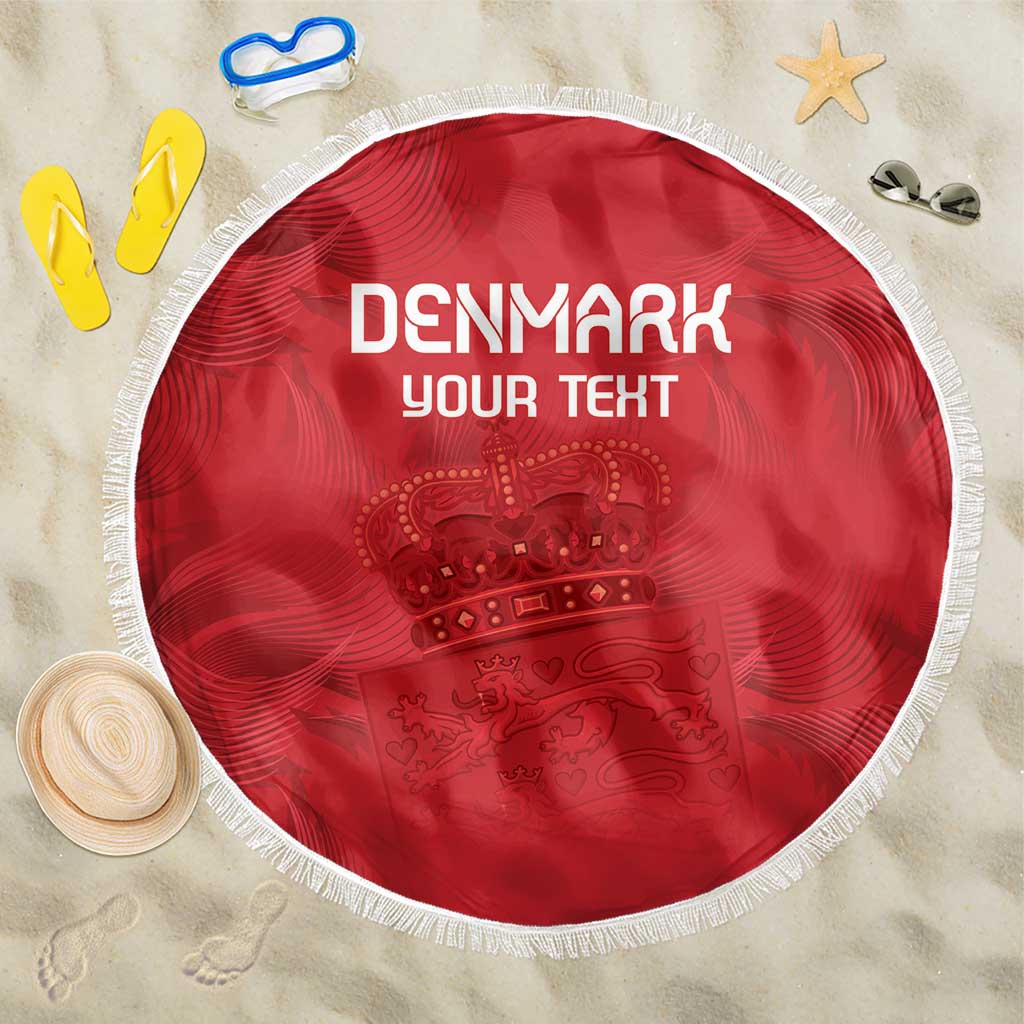 Round red Denmark-themed beach blanket with coat of arms graphic and white fringe edge.