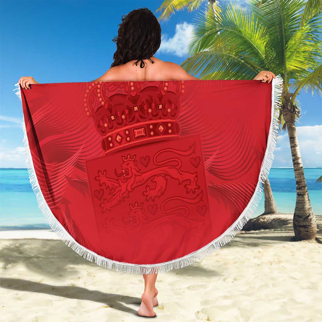 Red circular Denmark crest beach blanket with white fringe edge, held open.