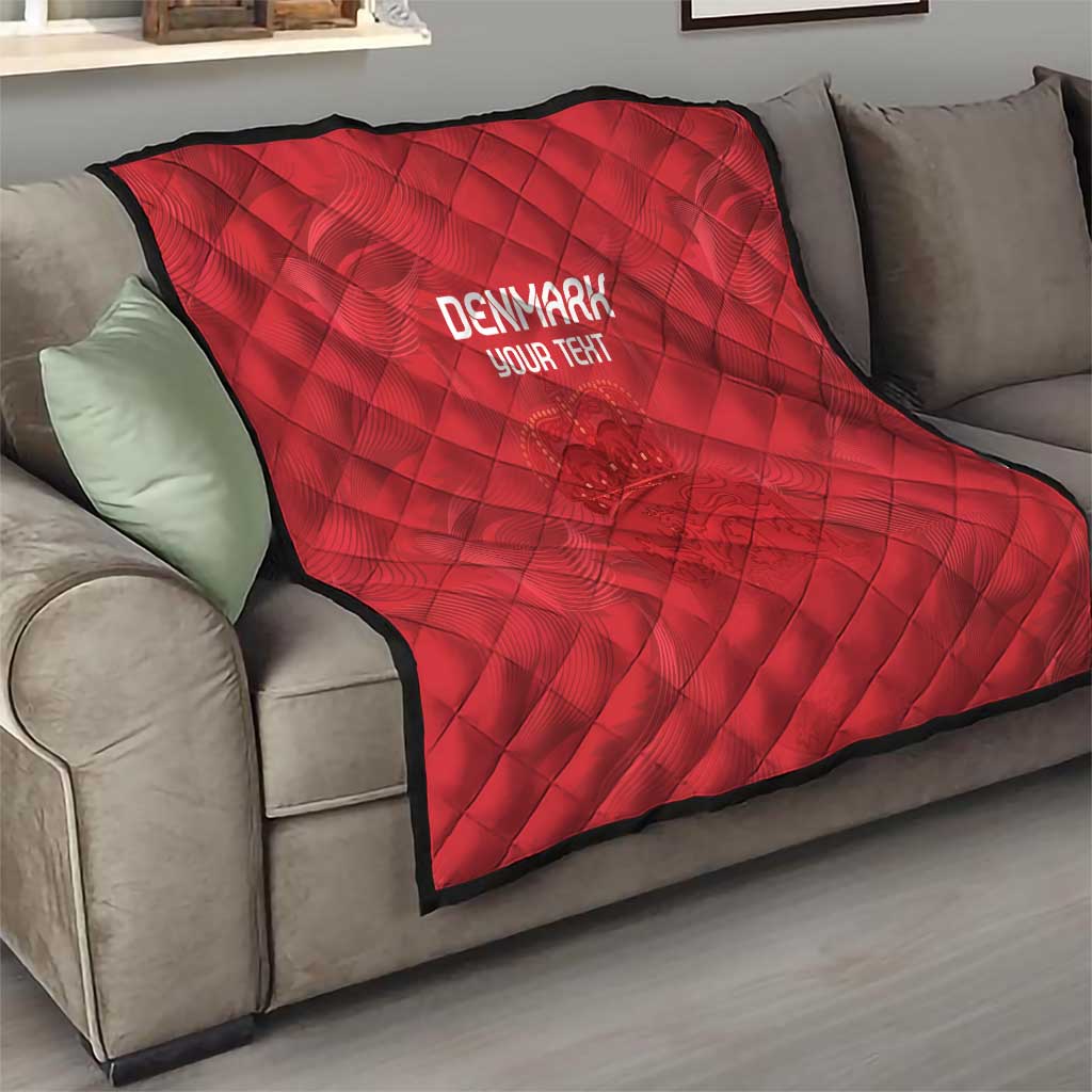 Red quilt draped on a sofa, diamond quilting, black trim, 'DENMARK' and 'YOUR TEXT'