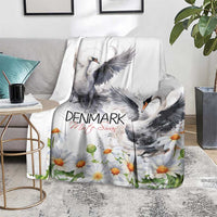 White mute swan blanket with daisy print, draped over a couch