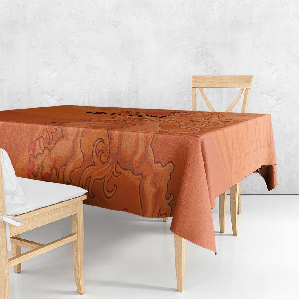 Orange football tablecloth with ornate lion design, draped over dining table