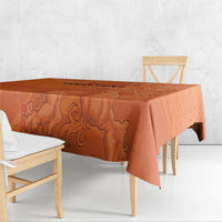 Orange football tablecloth with ornate lion design, draped over dining table