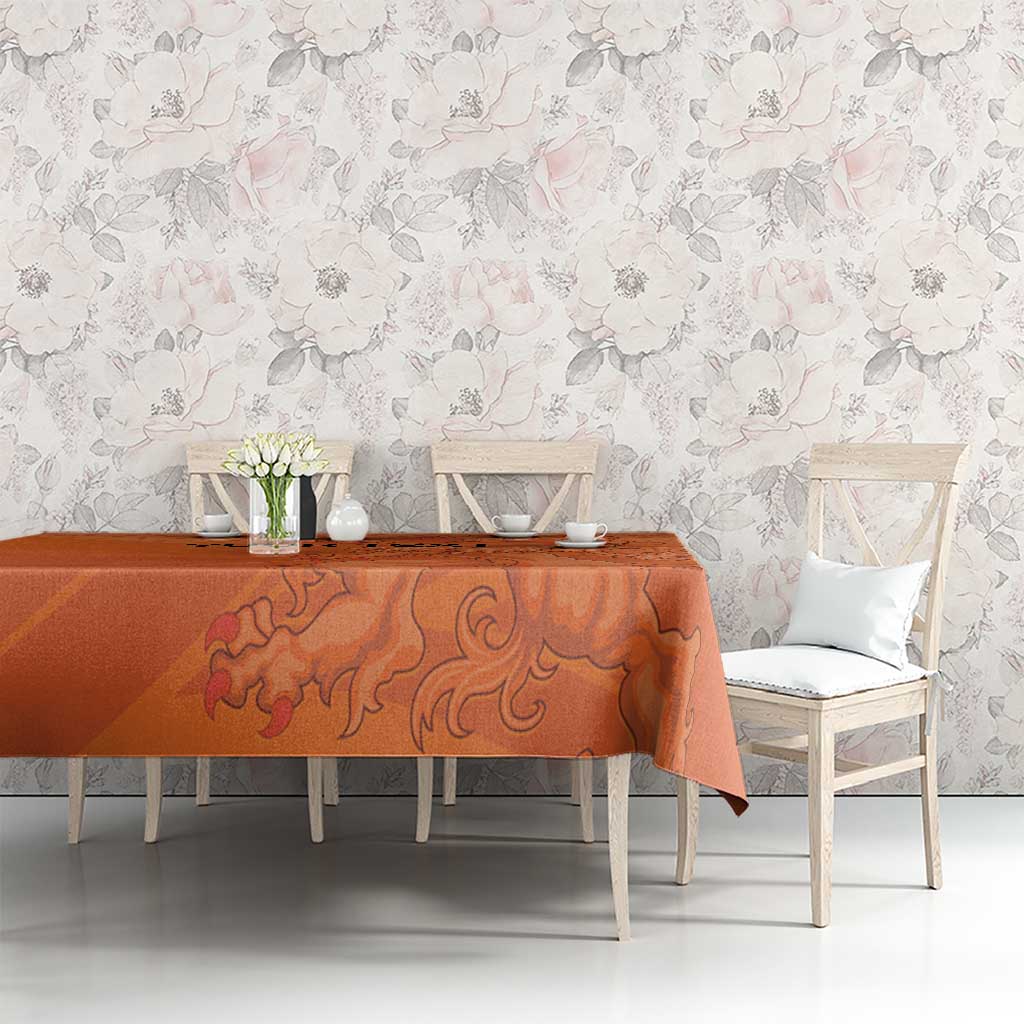 Orange football tablecloth with lion swirl graphic, covering dining room table