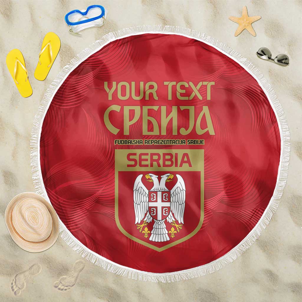 Red round Serbia beach blanket with white fringe and crest design, lying flat
