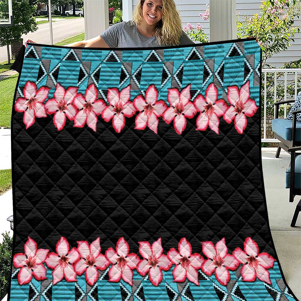 Black quilt blanket with teal Kente-style shapes and pink white floral rows, quilted