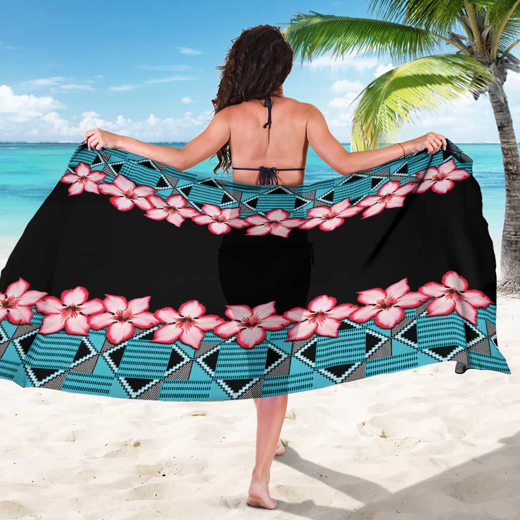 Back-view sarong draped over shoulders: pink flower print, teal geometric border, black