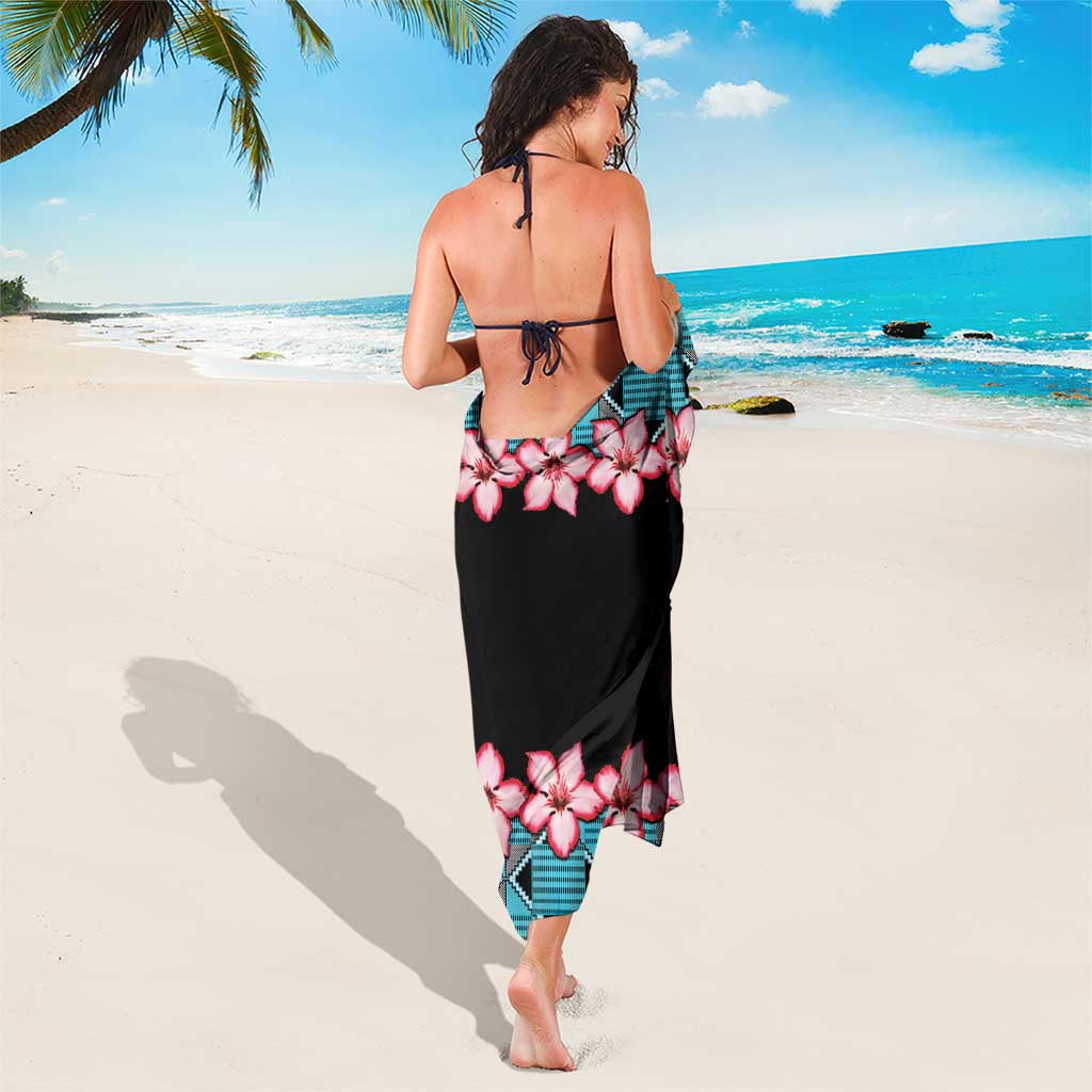 Sarong with pink hibiscus flowers and teal kente-style diamond border on black fabric