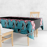 Rectangular tablecloth draped over table edge, black background with red hibiscus and blue