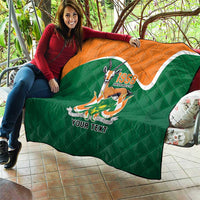 Green quilted throw quilt with orange top, central emblem and 'YOUR TEXT' printed