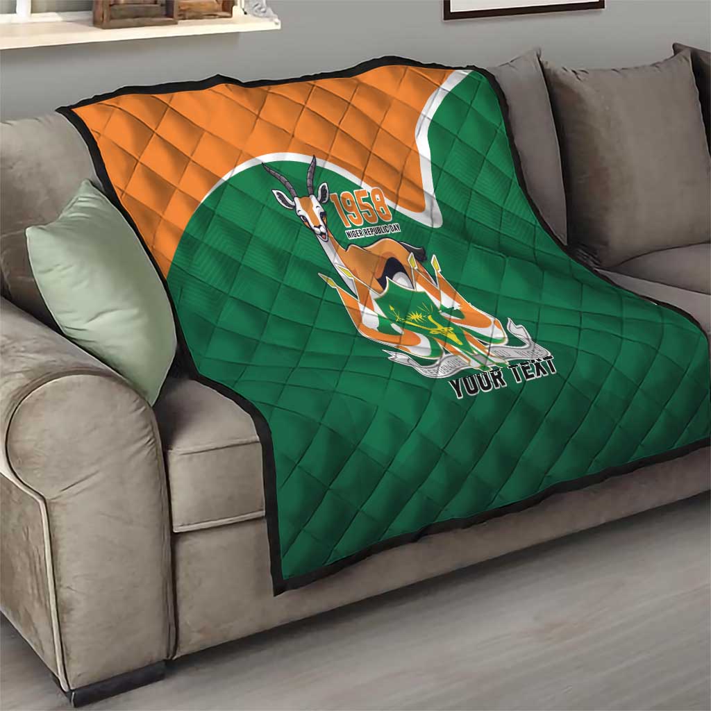 Green quilted throw quilt with orange top, emblem graphic and 'YOUR TEXT' detail