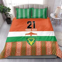 Custom bedding set on bed with matching pillows, number 21 and Niger emblem in green/orange/white