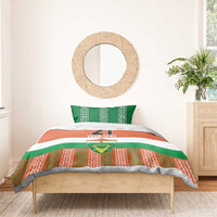 Custom bedding set on wooden bed with orange/green/white duvet, number 21, and Niger emblem