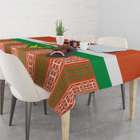 Orange tablecloth with green and white tribal pattern, draped over table