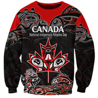 Red crewneck sweatshirt with black Indigenous art graphic and central Canada text