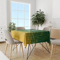 Green and yellow cricket-themed tablecloth on dining table with multiple chairs and decor