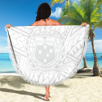 Round white beach blanket with gray Polynesian crest design, tassel fringe, held up