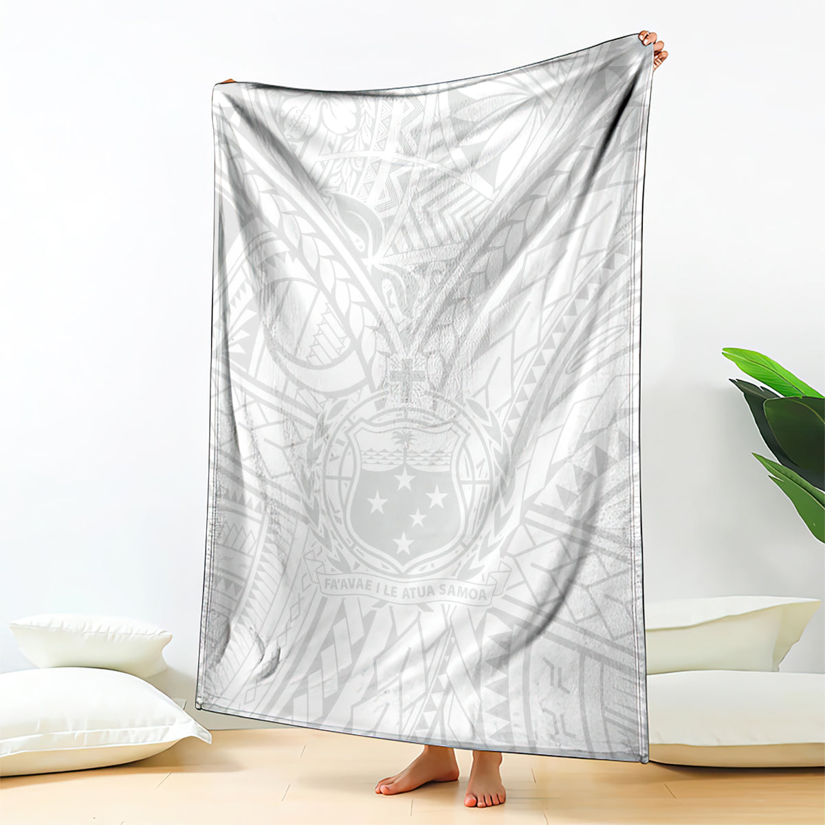 White kid's blanket with Polynesian tribal crest and geometric pattern, draped over floor
