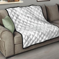 White quilt with diamond quilting on sofa, black border around the edges.