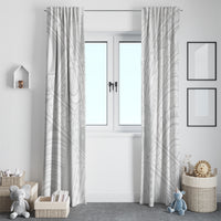 White patterned window curtains, gathered at top and hanging on both sides of door
