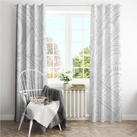 White patterned curtain panels with geometric motifs, hanging on either side of window