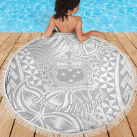 Round white fringed beach blanket showing Samoa crest and decorative wave motif