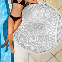 White round beach blanket with fringed edge, Samoa emblem and tropical leaf pattern
