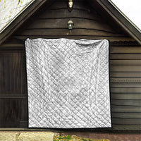 White quilt with black border hanging on a porch with repeating tropical Polynesian pattern