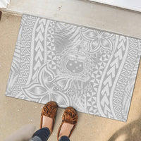 Rectangular rubber doormat with light gray base and white Polynesian text, crest, and leaf design