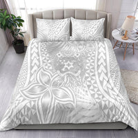 White bedding set with two patterned pillowcases and duvet, tropical leaf and tribal crest design