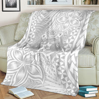 Personalized white blanket draped over furniture, gray crest and leaf designs with triangle pattern