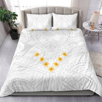 White duvet cover and two pillows with tribal pattern and yellow plumeria flower accents