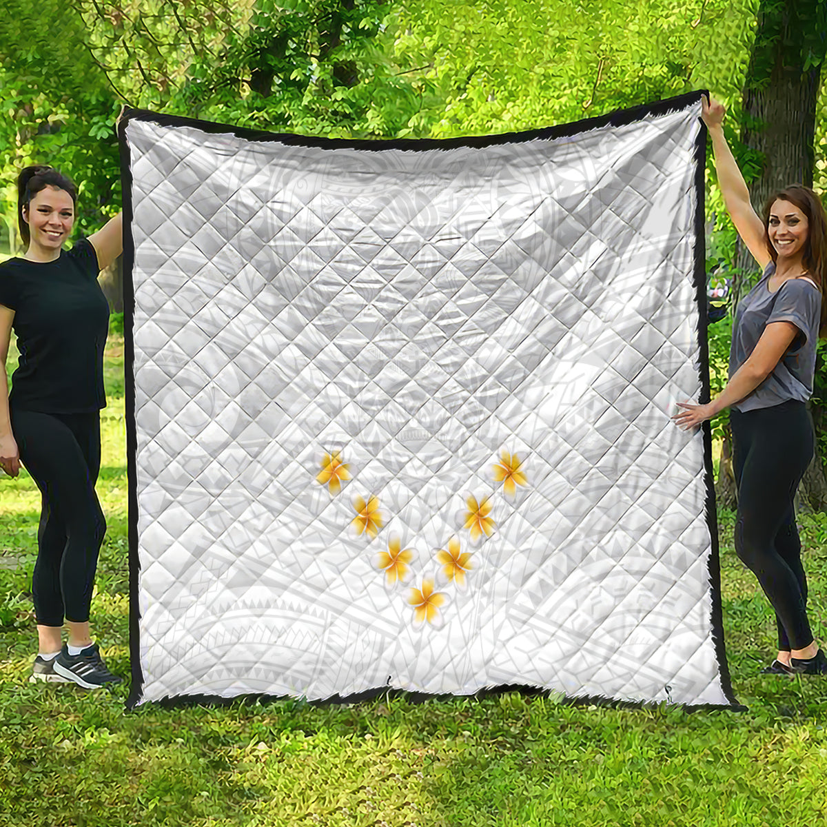 White quilt with diamond quilting and yellow plumeria flower motif, large view