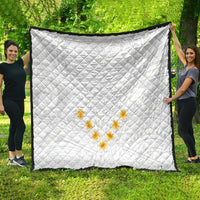 White quilt with diamond quilting and yellow plumeria flower motif, large view