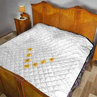 White quilt on bed with diamond quilting and yellow plumeria floral applique