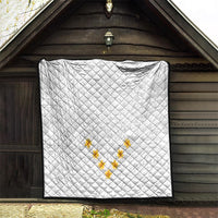 White quilt hung on wall with diamond quilting and yellow plumeria motif