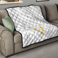 White quilt with diamond quilting and yellow plumeria motif on couch