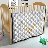 White quilt with diamond stitching and yellow plumeria applique on baby bed