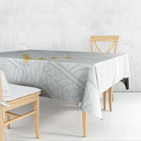 Gray and white tablecloth with geometric pattern draped over dining table