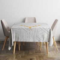Square white tablecloth with gray geometric pattern, centered on dining table
