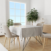 White tablecloth with gray geometric motif and yellow accents on dining table