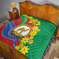 Green quilt on a bed with Eritrea stripes, yellow flowers, camel emblem, and custom text.