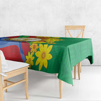 Green printed tablecloth with blue and red flag bands and large yellow flowers