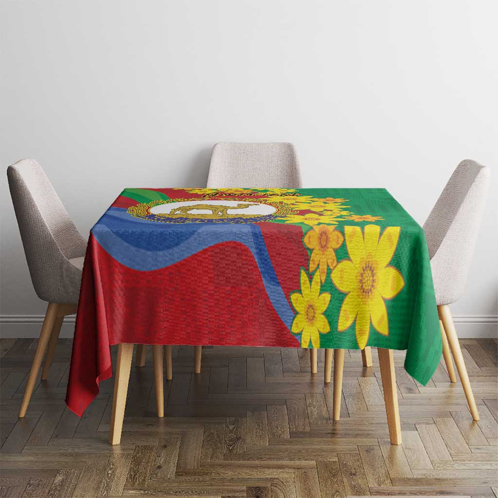 Green and red tablecloth with yellow floral print and multicolor emblem
