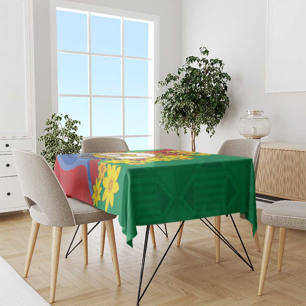 Green tablecloth with yellow flower print and multicolor emblem panels