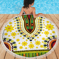 White round beach blanket showing full V-shaped dashiki motif, yellow flowers, and fringe