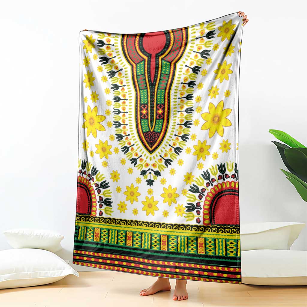 White blanket with bold dashiki motifs, yellow flowers, red and green banded border