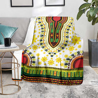 White dashiki-pattern blanket with yellow flower clusters and colorful striped hem